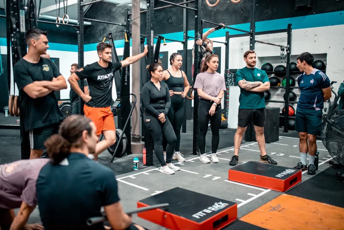 Coach expliquant un mouvement d'haltérophilie à un groupe au CrossFit Gratte-Ciel à Villeurbanne